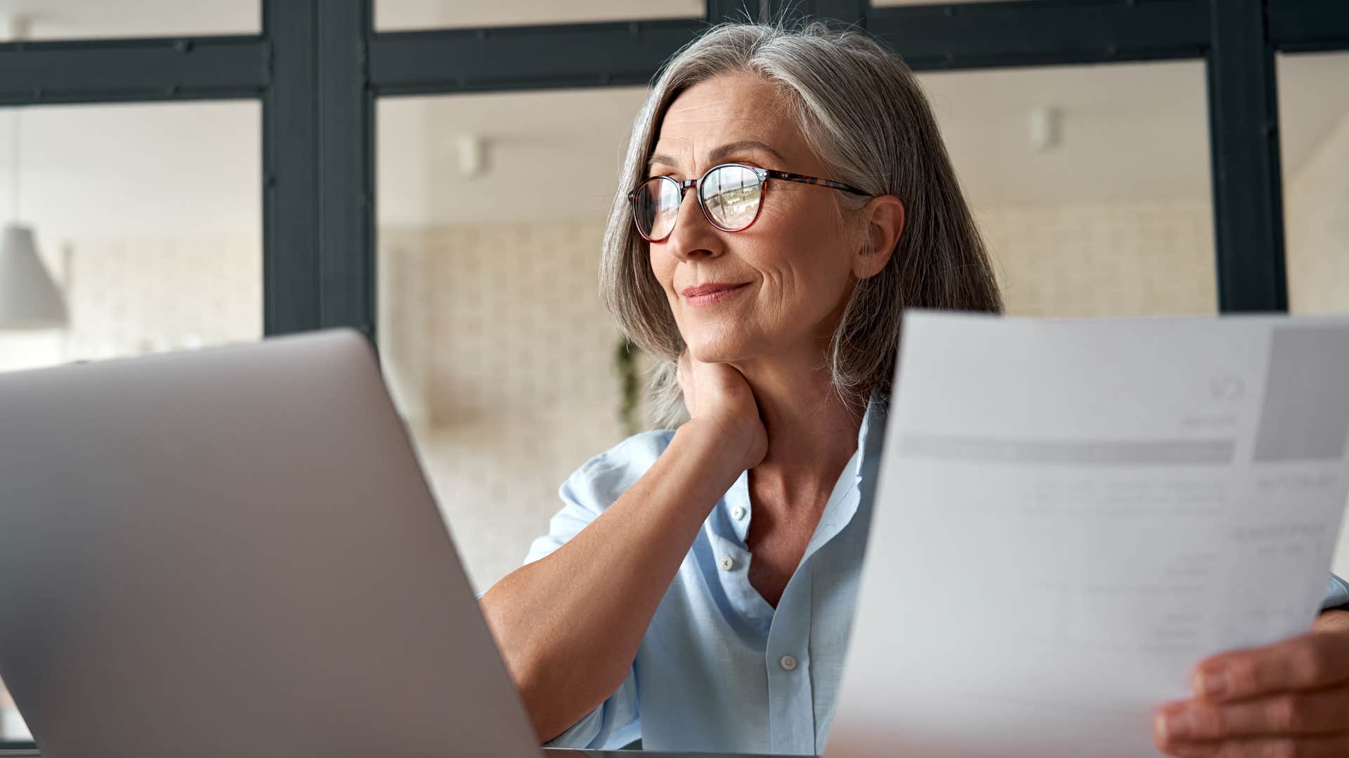 woman in blue shirt has increased motivation as she stares at laptop