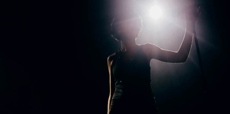 A famous actress, backlit on stage, sharing the big lesson she learned 