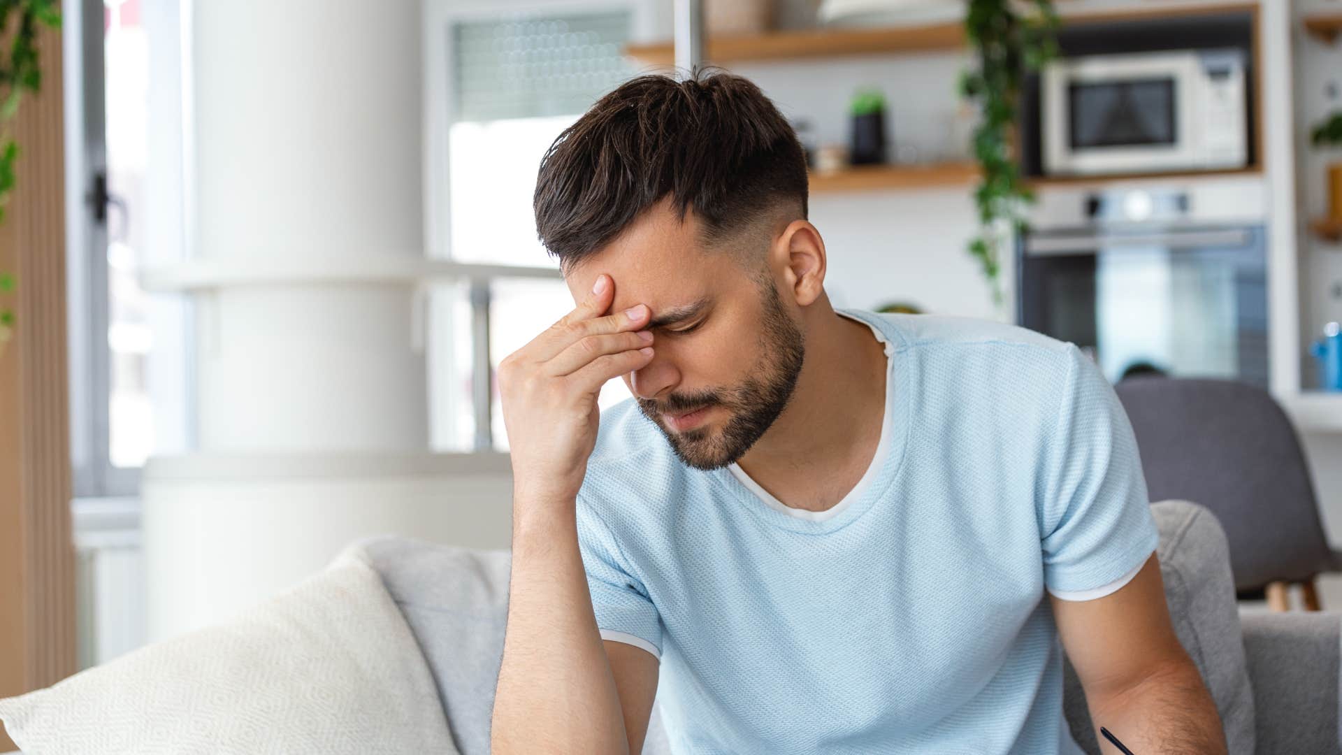 man who has the migraine symptom of pain with touch