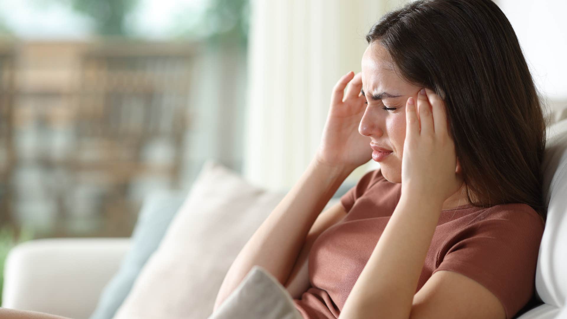woman feeling pressure as a migraine symptom