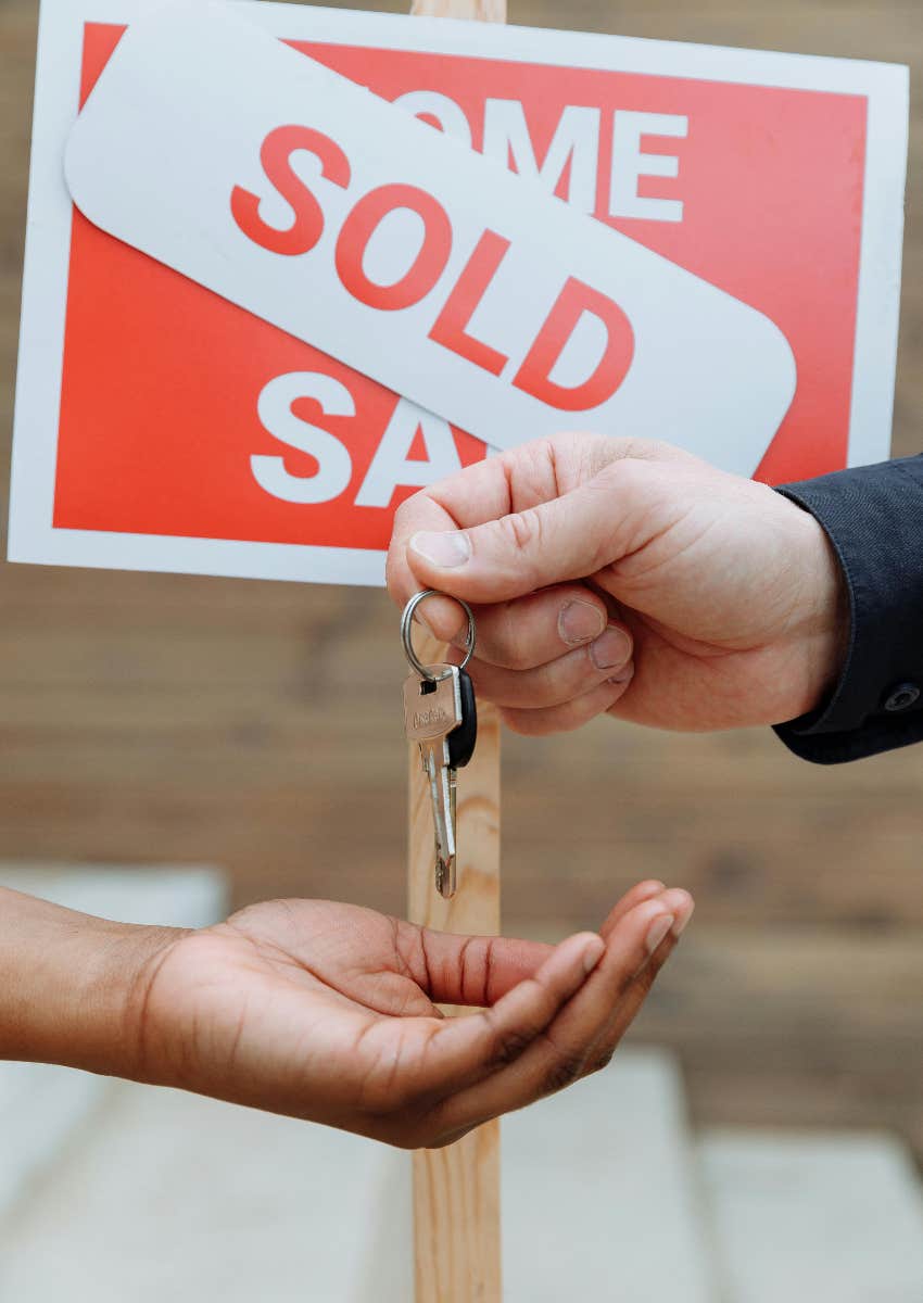 person being handed the keys to the house they just bought