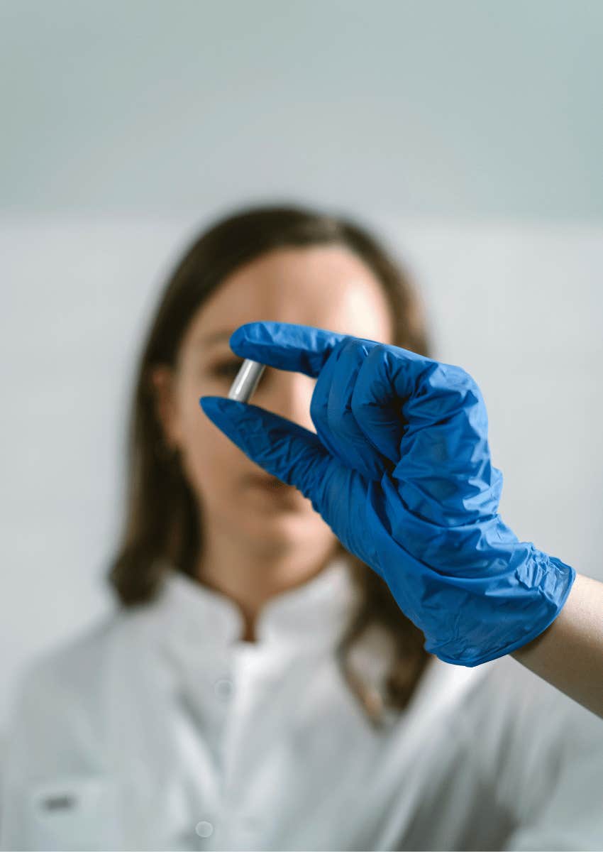 gloves hand holding a capsule