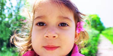 A woman holding a microphone and tablet while speaking indoors in a relaxed setting.