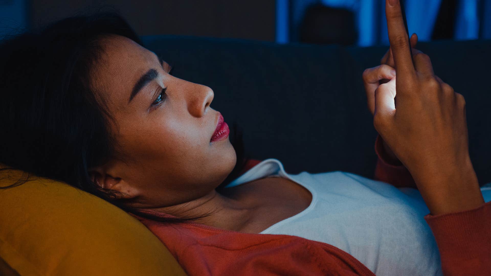 Woman dealing with her burnout scrolling on her phone.