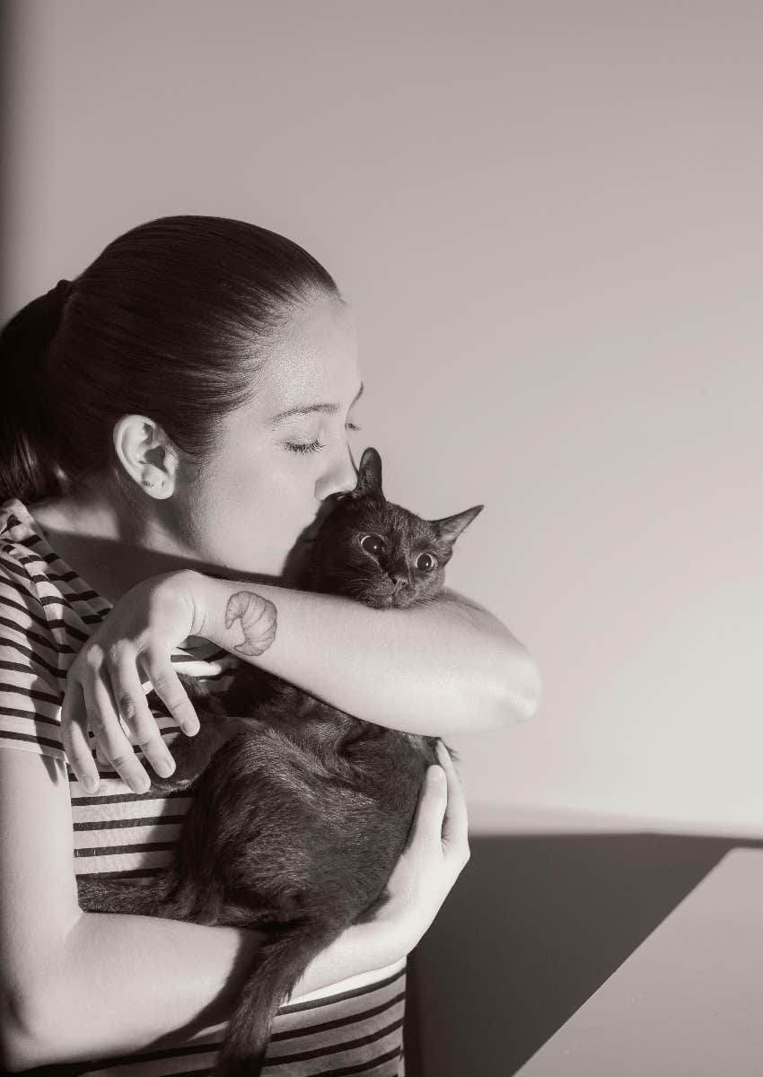 woman with a tattoo holding a cat