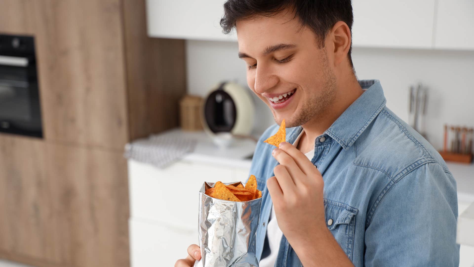 man snacking in the kitchen