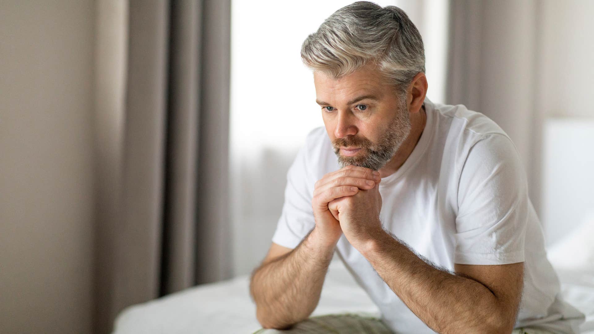 Man who can avoid confrontation and conflict sitting on his bed.