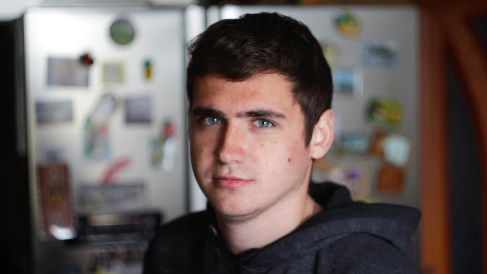 serious young man looking at camera indoors