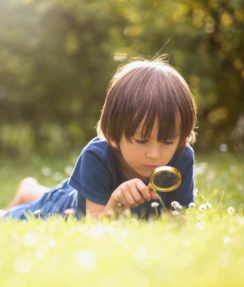 inquisitive child studies nature with magnifying glass showing homeschool habit