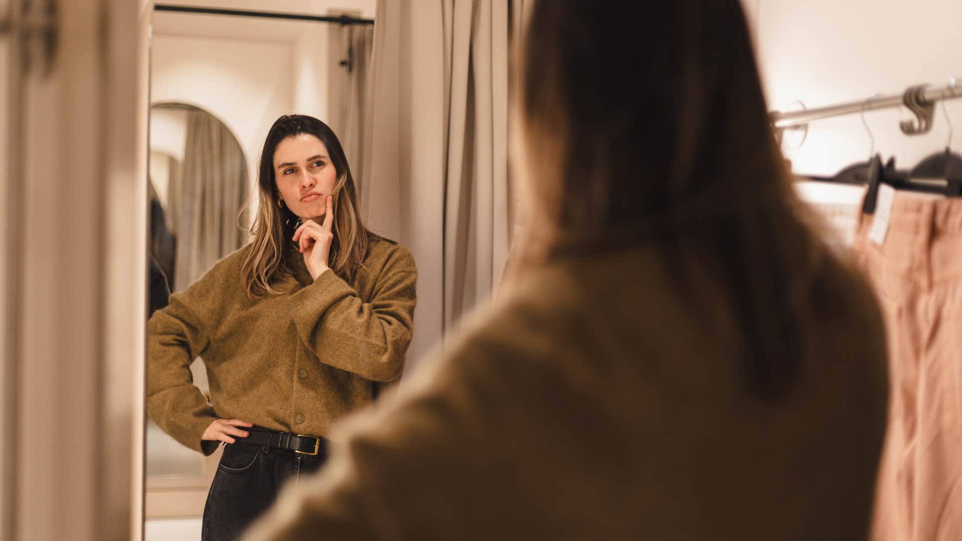 woman deciding on shirt in mirror