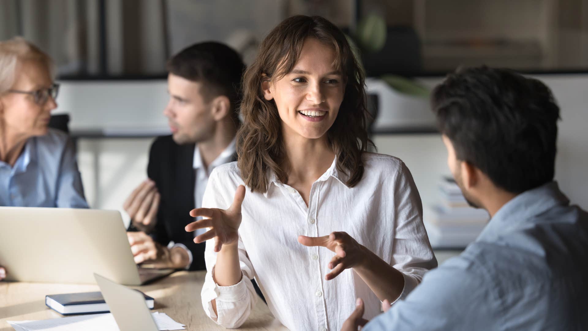 woman in white shirt talking to coworker as she overexplains herself