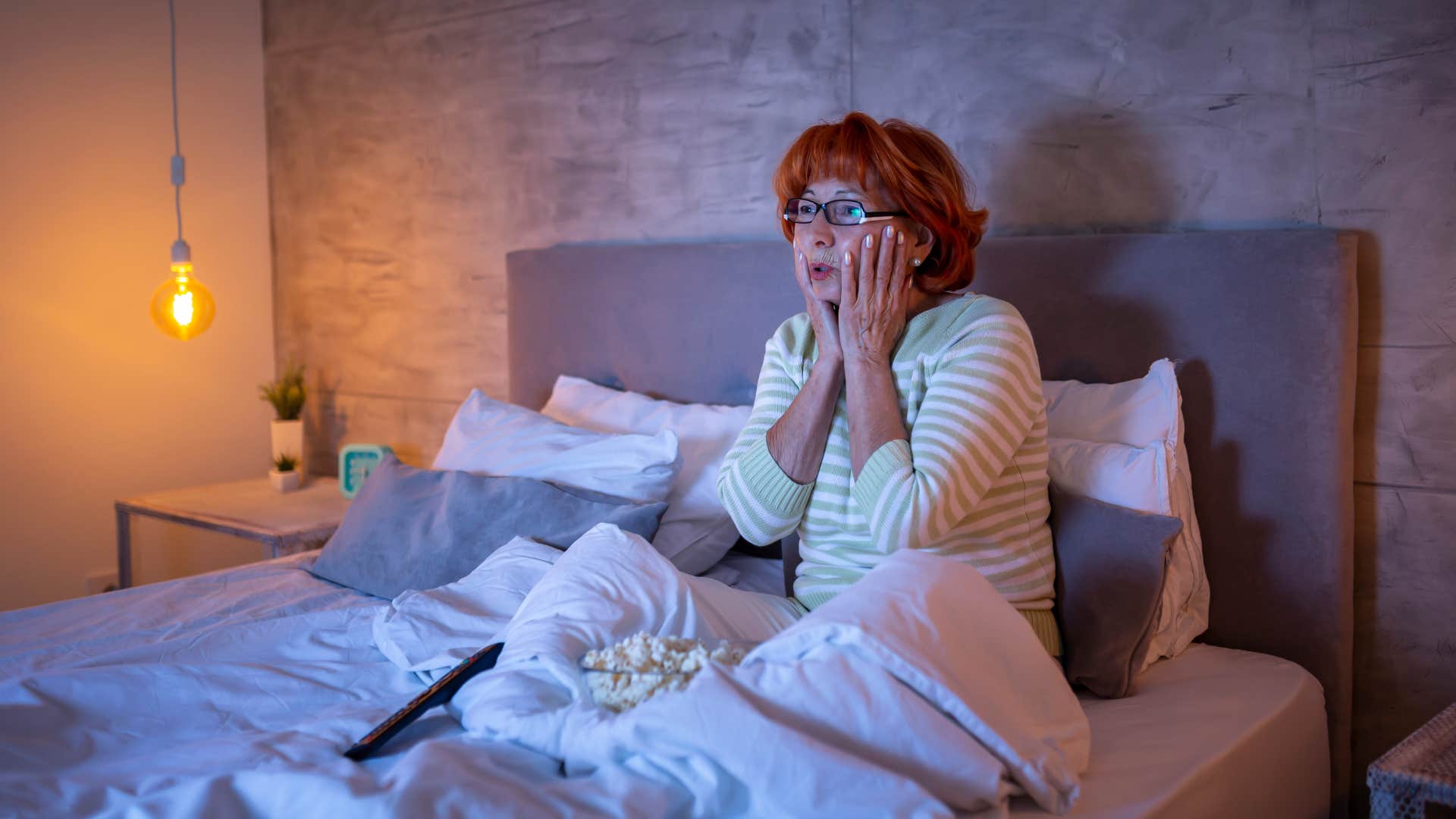 woman watching tv in bed