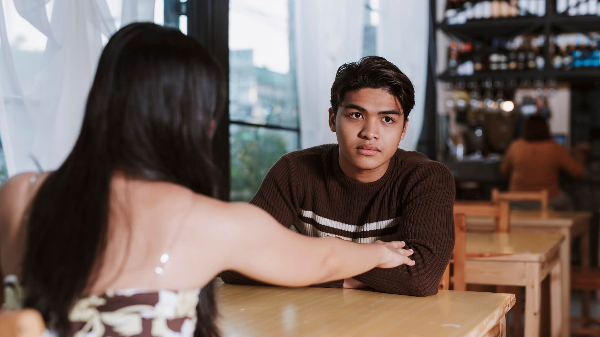 Person who grew up differently looks away from friend showing trust issues