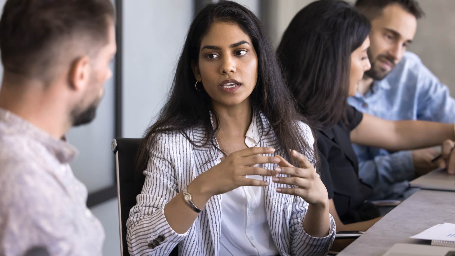 woman talking to lazy colleague taking advantage at work