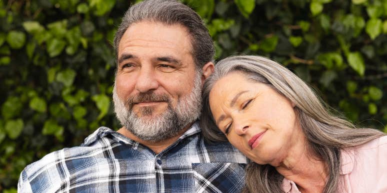 woman resting head on man's shoulder