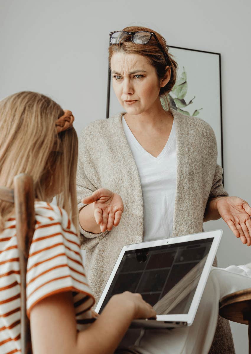 serious mom hovering over her young child