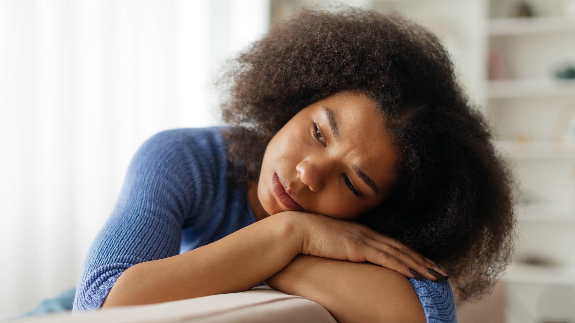 Bleak person rests head on arm showing burnout