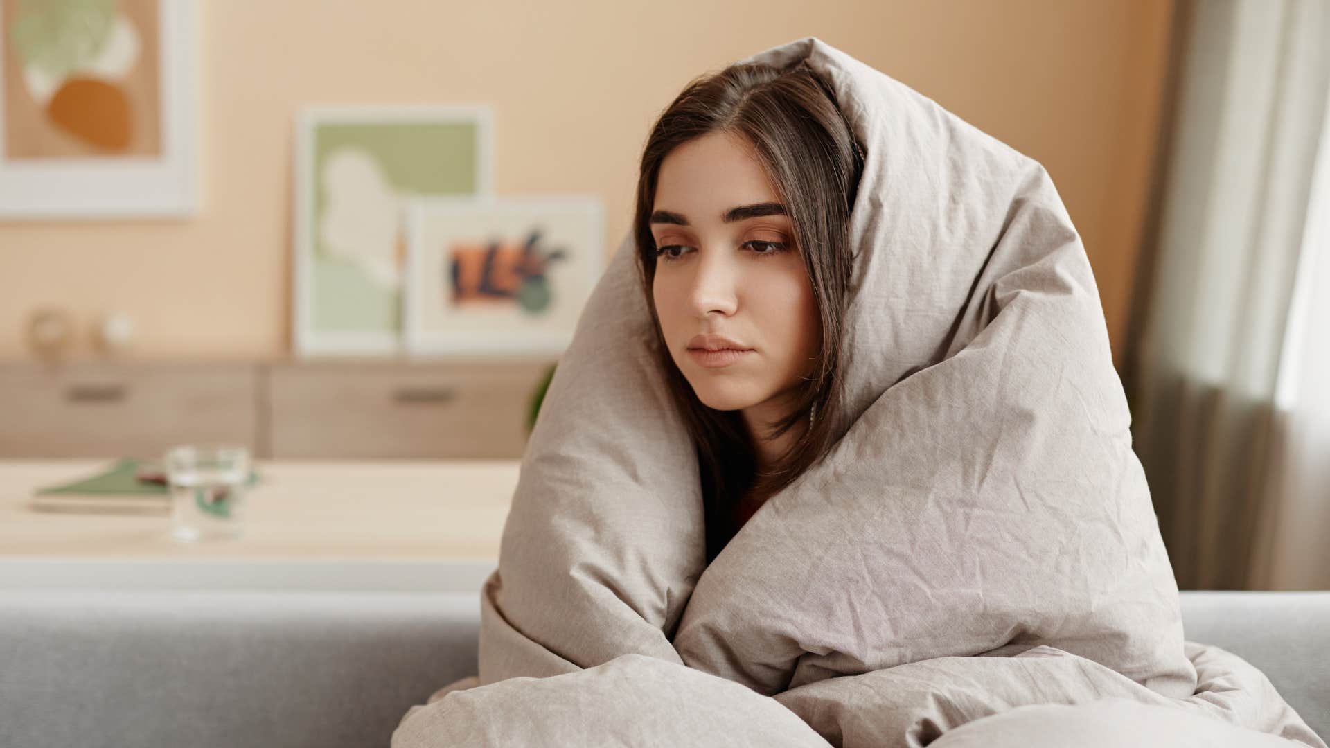Tired person wrapped in blanket showing burnout needs attention