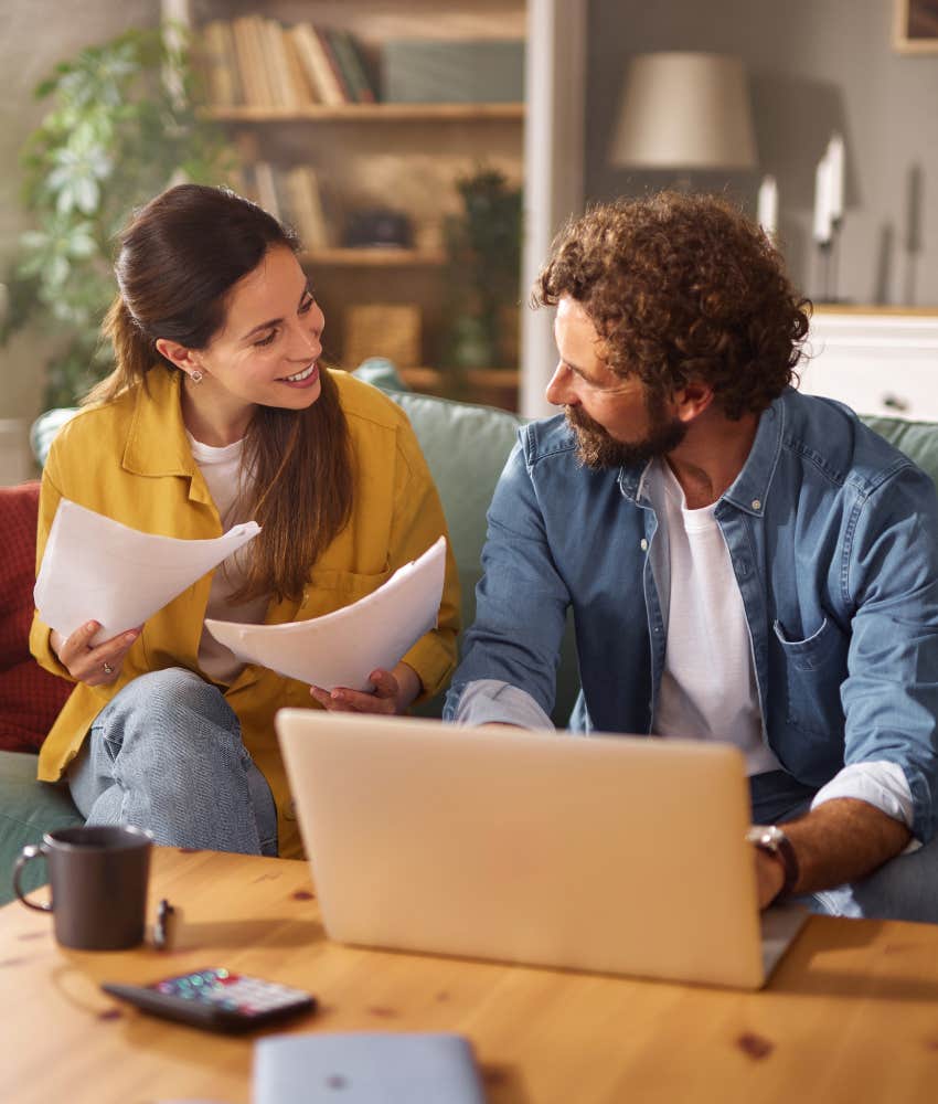 Communicative couple on couch with paperwork showing agreement to make marriage work