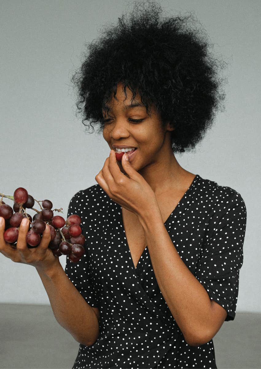 smiling woman eating graps