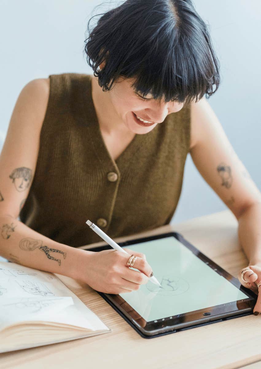 smiling young woman drawing on an ipad