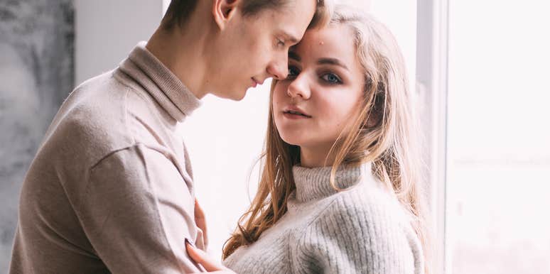 Young couple by a window, woman worried that his behavior is a relationship ender