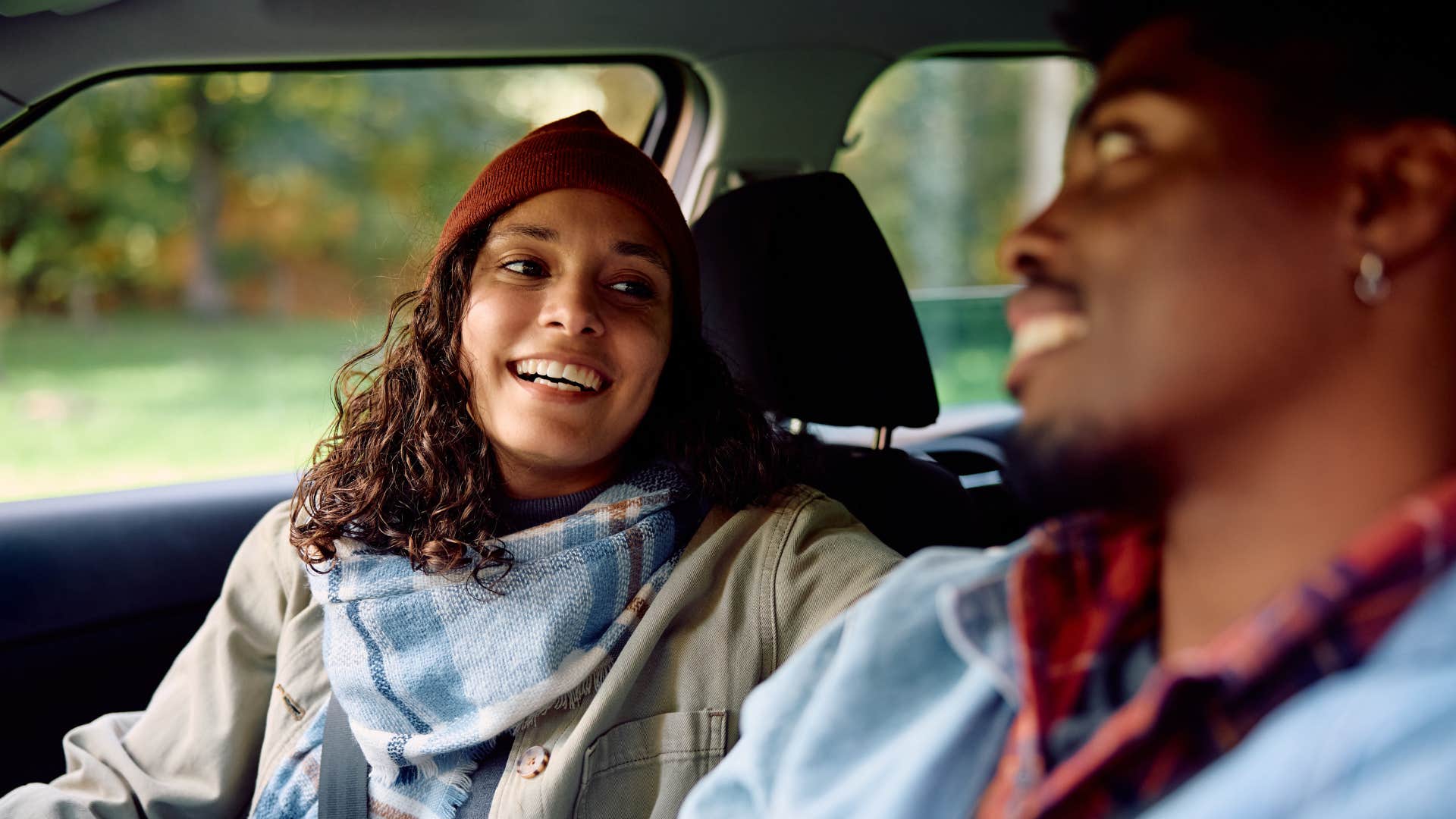 woman and man smiling in car as woman suggests another resturant 