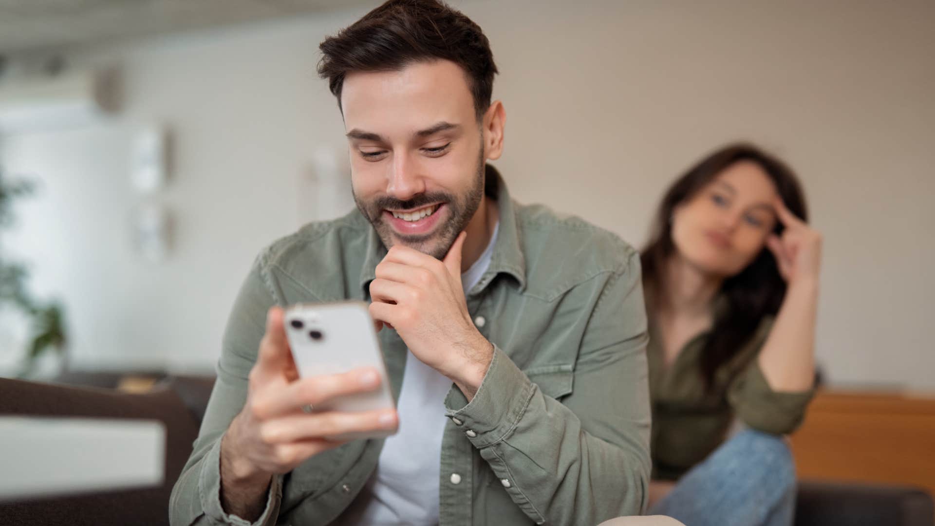 man on phone prioritizing friends over his upset partner