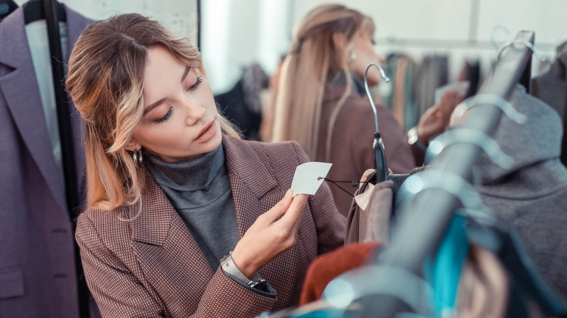 wealthy woman checking price tags on clothing
