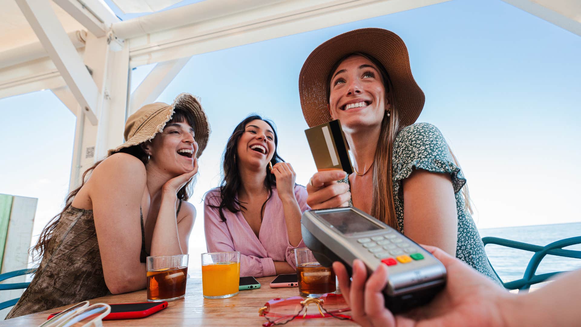 wealthy woman paying for her friends food and drinks