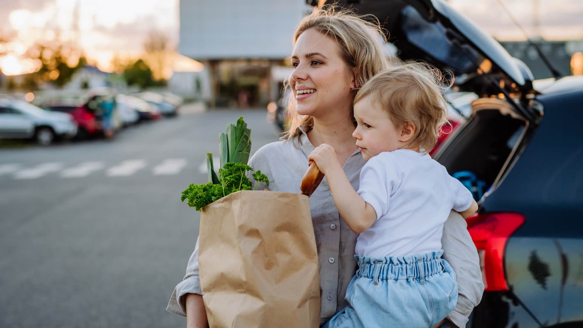 woman carrying fresh produce in grocery store parking lot