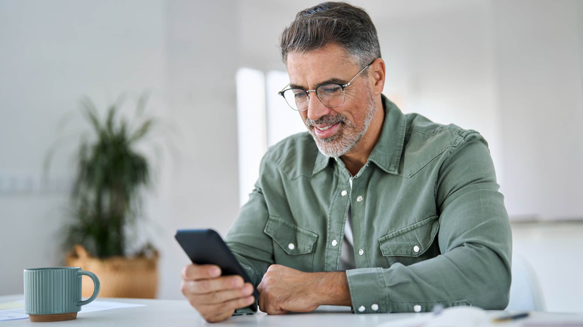 man looking over company retirement plans on his phone