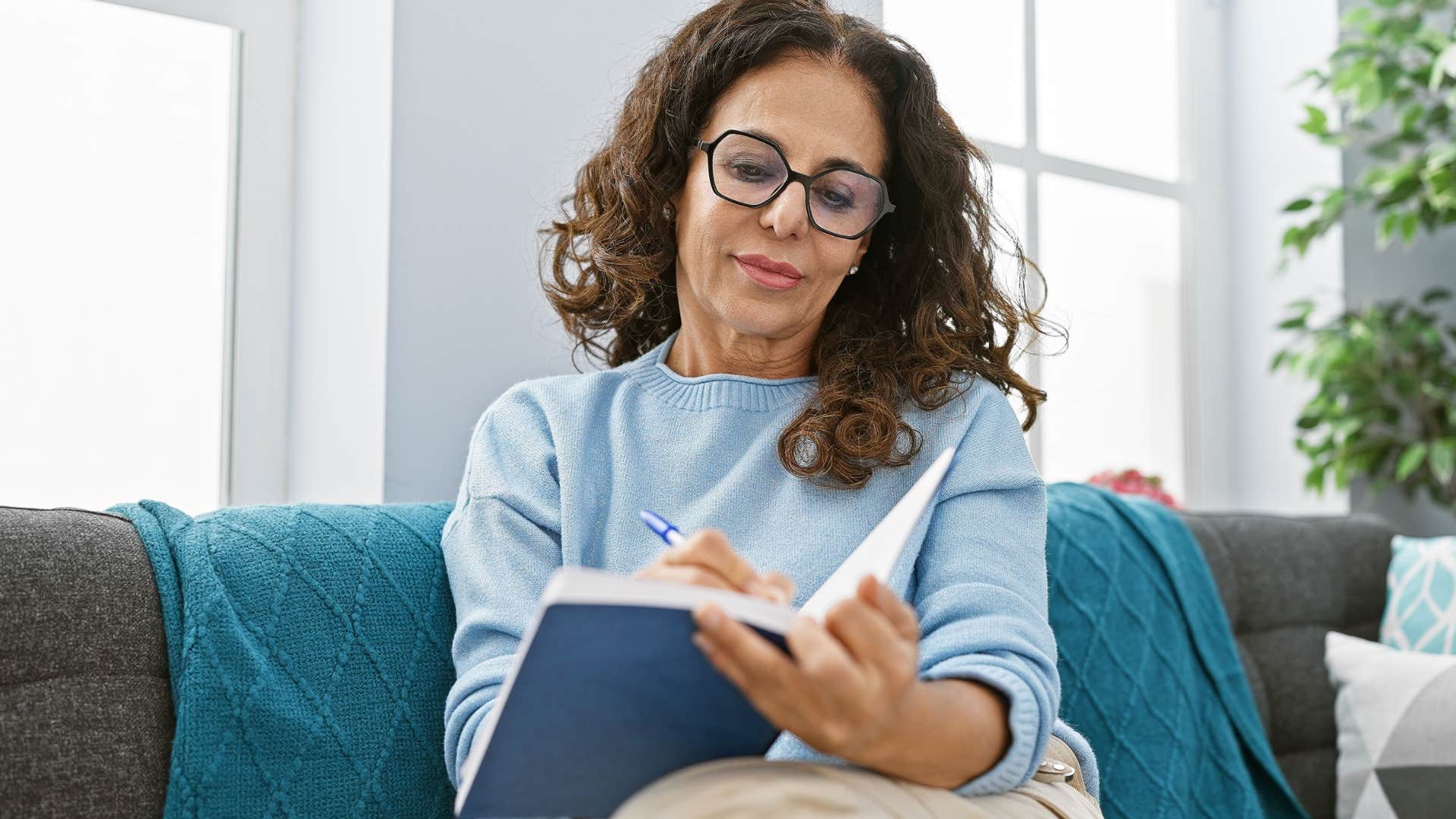 smart woman smiling and journaling in a notebook