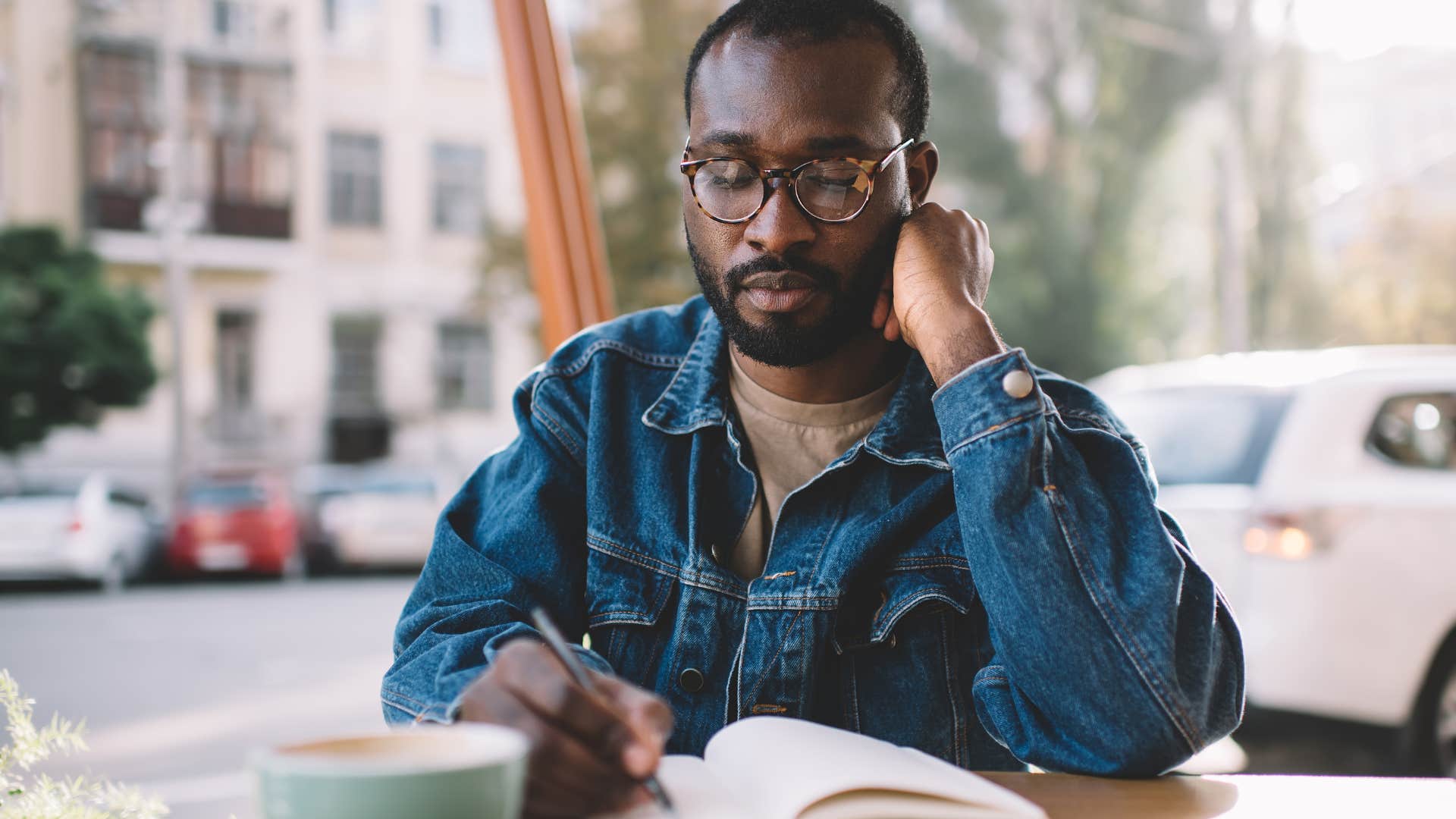 smart man organizing in a planner at a coffee shop