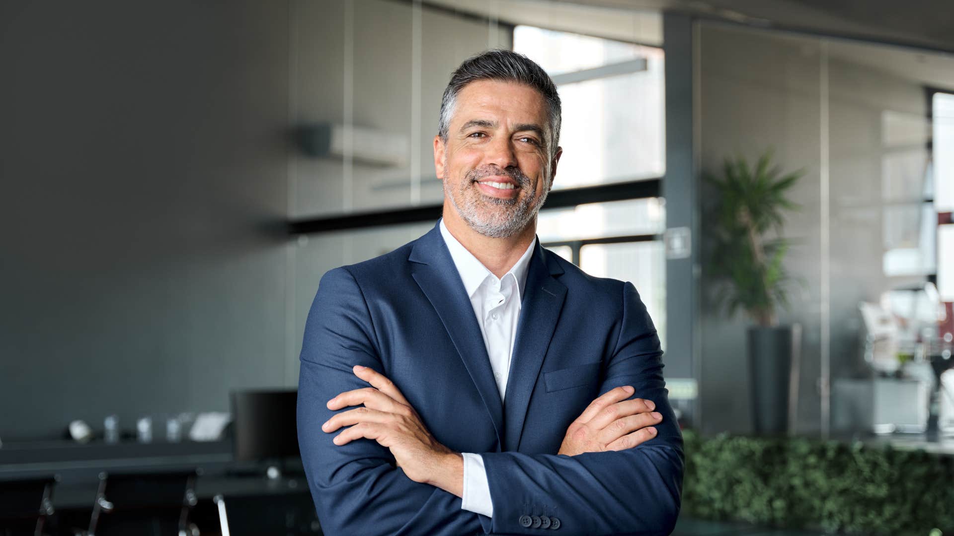 man in suit smiling as he doesn't show off his success he lets it be noticed