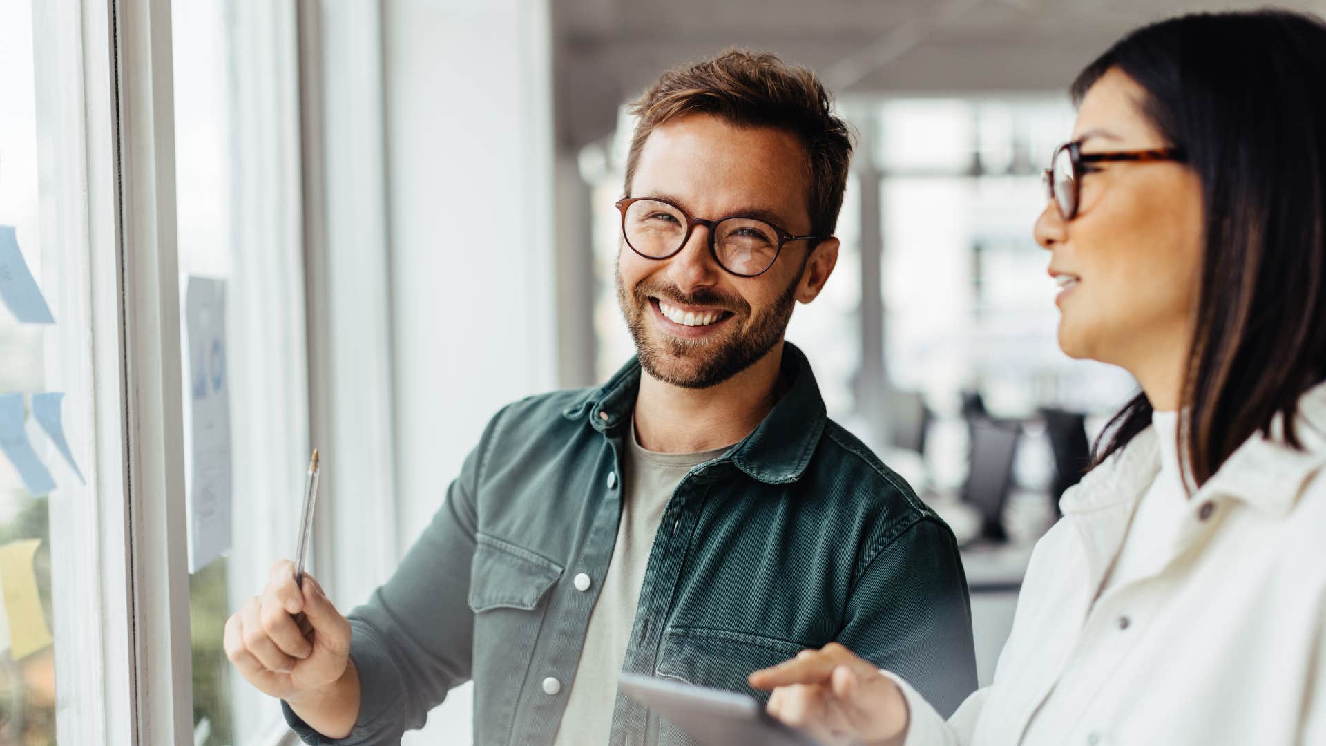 man in glasses smiling as he never asks about salary at job