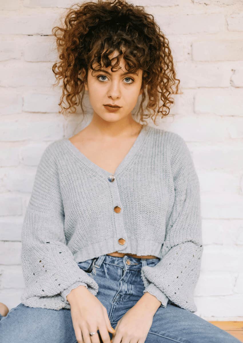 woman with curly hair with a serious expression
