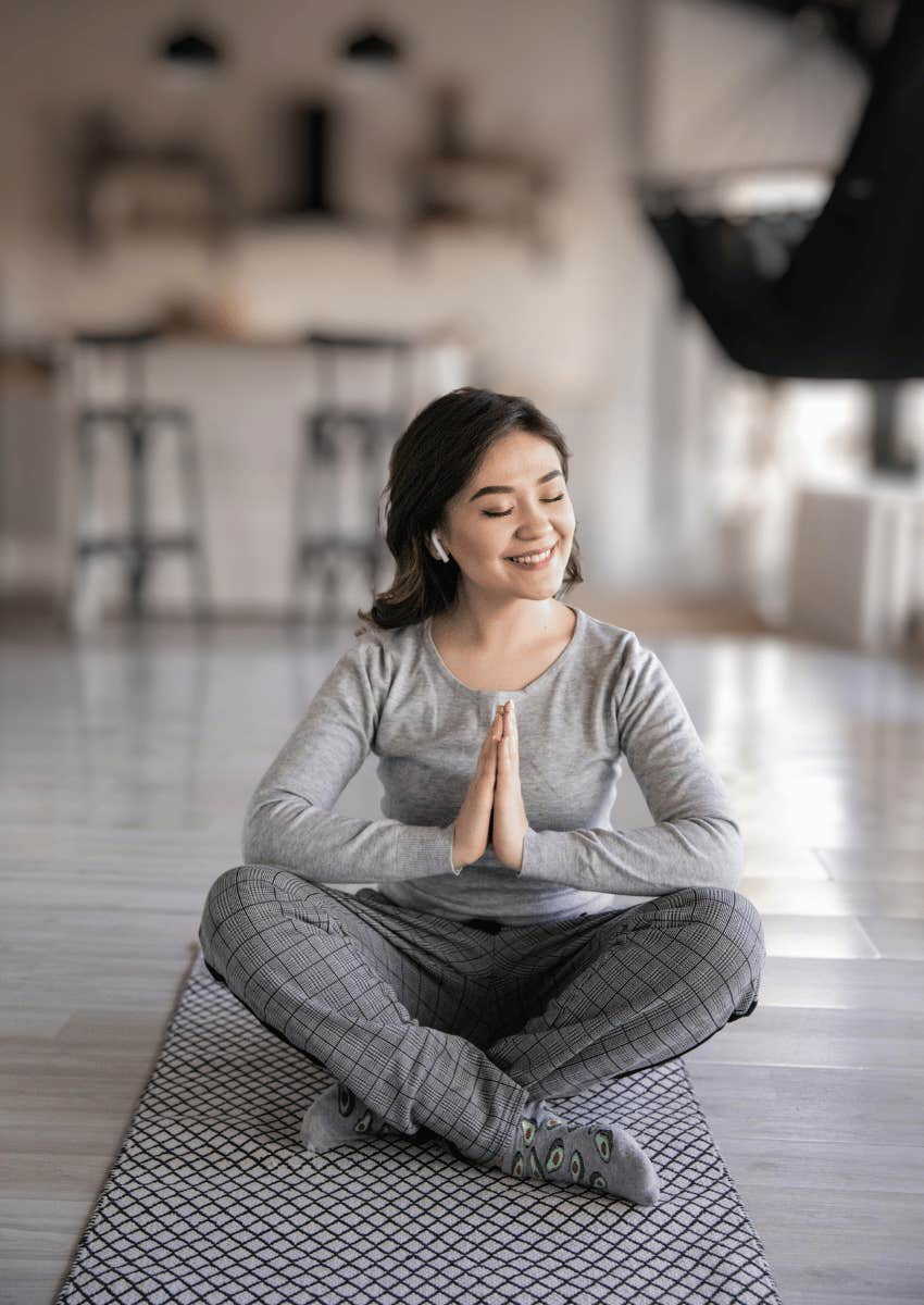 woman smiling while meditating first thing in the morning