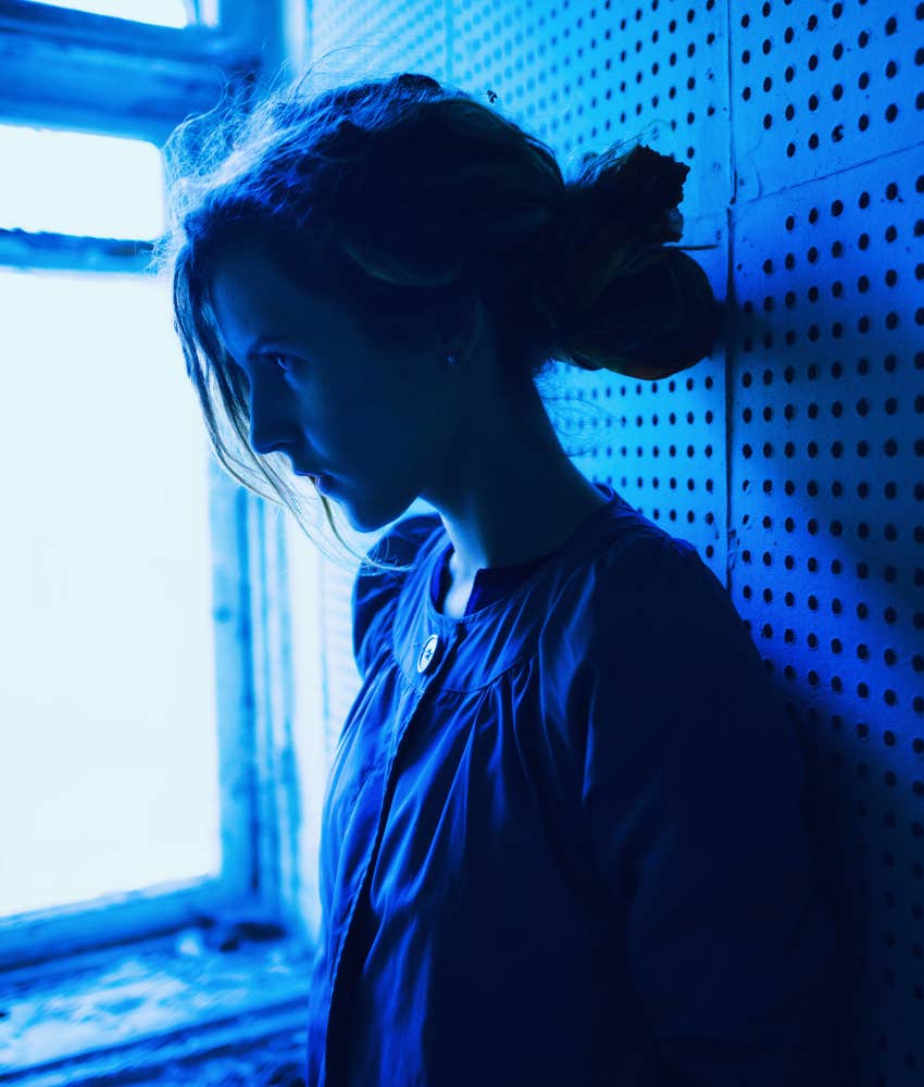 Struggling person leans against wall showing uncomfortable realness