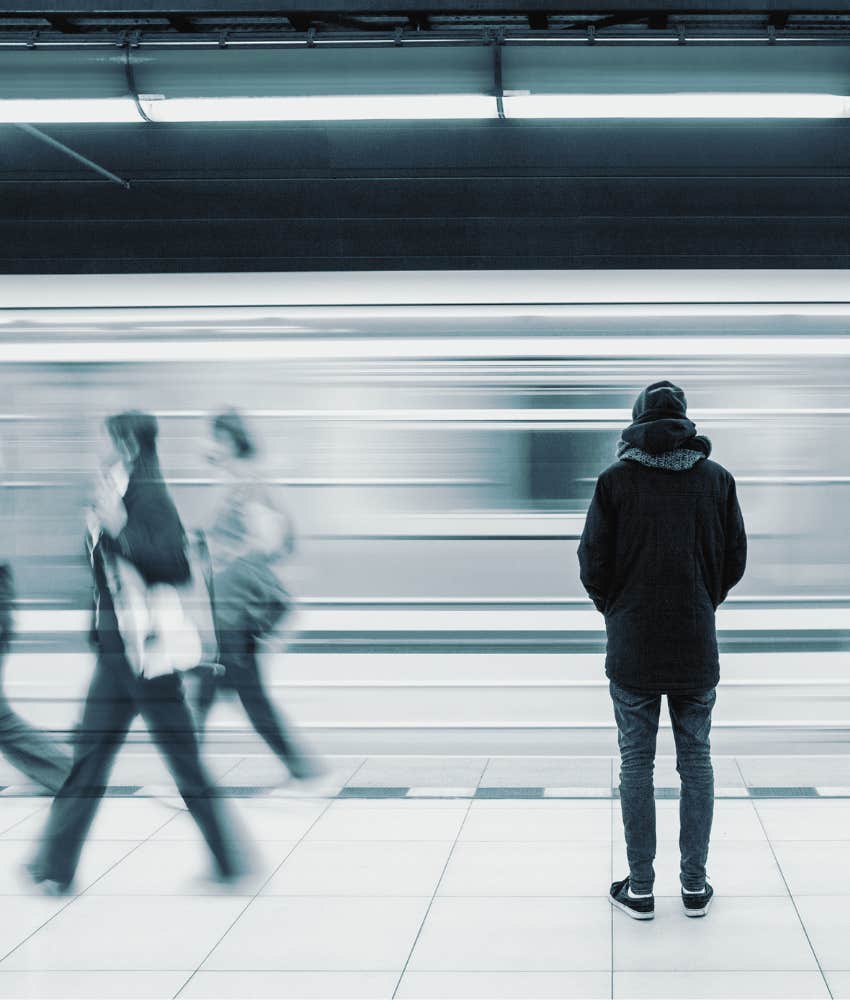 Lone individual stand still while others pass by showing uncomfortable realness