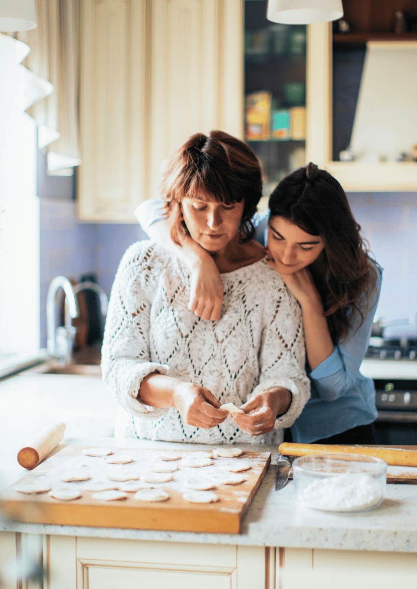 young woman hugging her parent in the kitchen